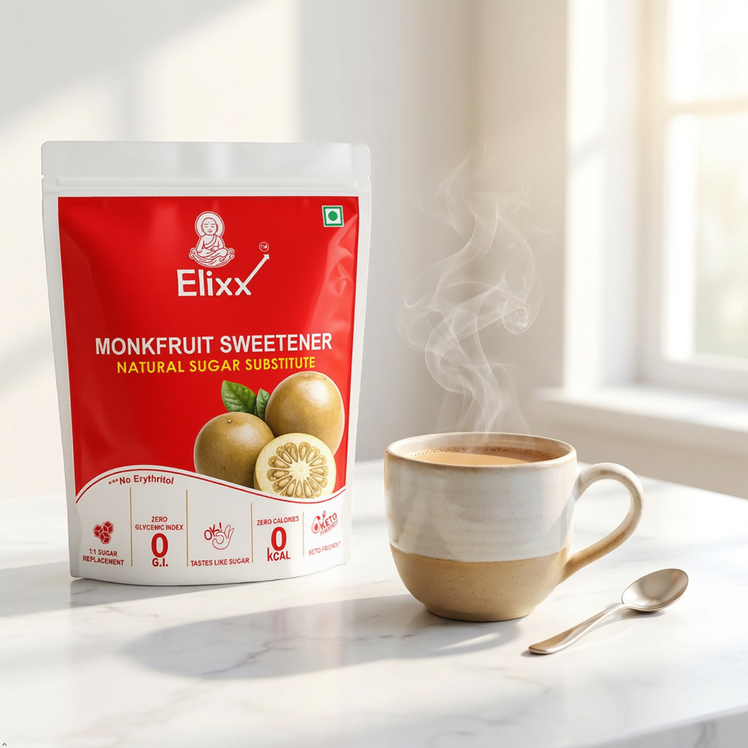 A stand-up pouch of ElixX Monkfruit Sweetener sits on a light marble surface beside a ceramic cup of steaming chai and a spoon, with a softly blurred kitchen-like background.